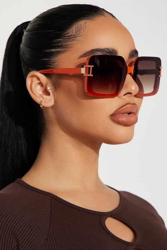 Woman wearing red sunglasses with a plain background