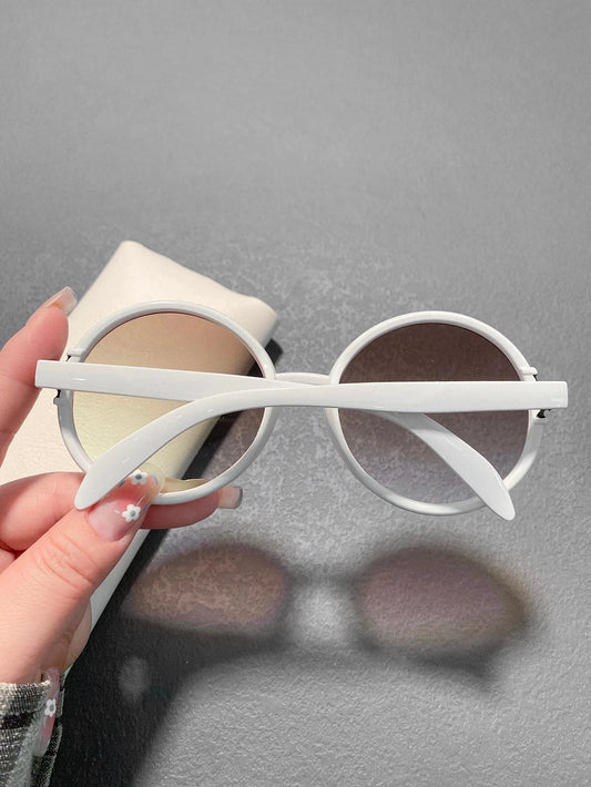 White sunglasses held by a hand against a gray background