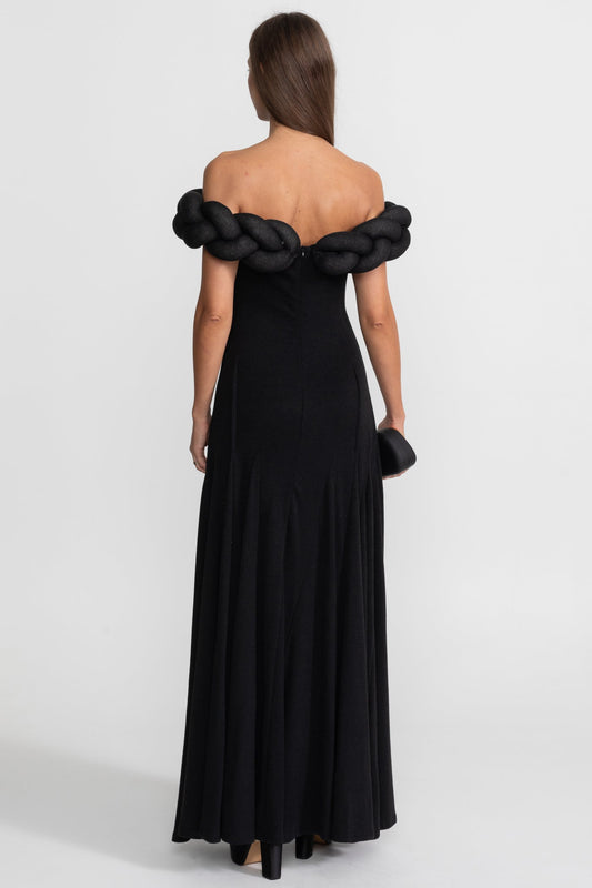 Black off-shoulder evening gown with braided detailing on a white background
