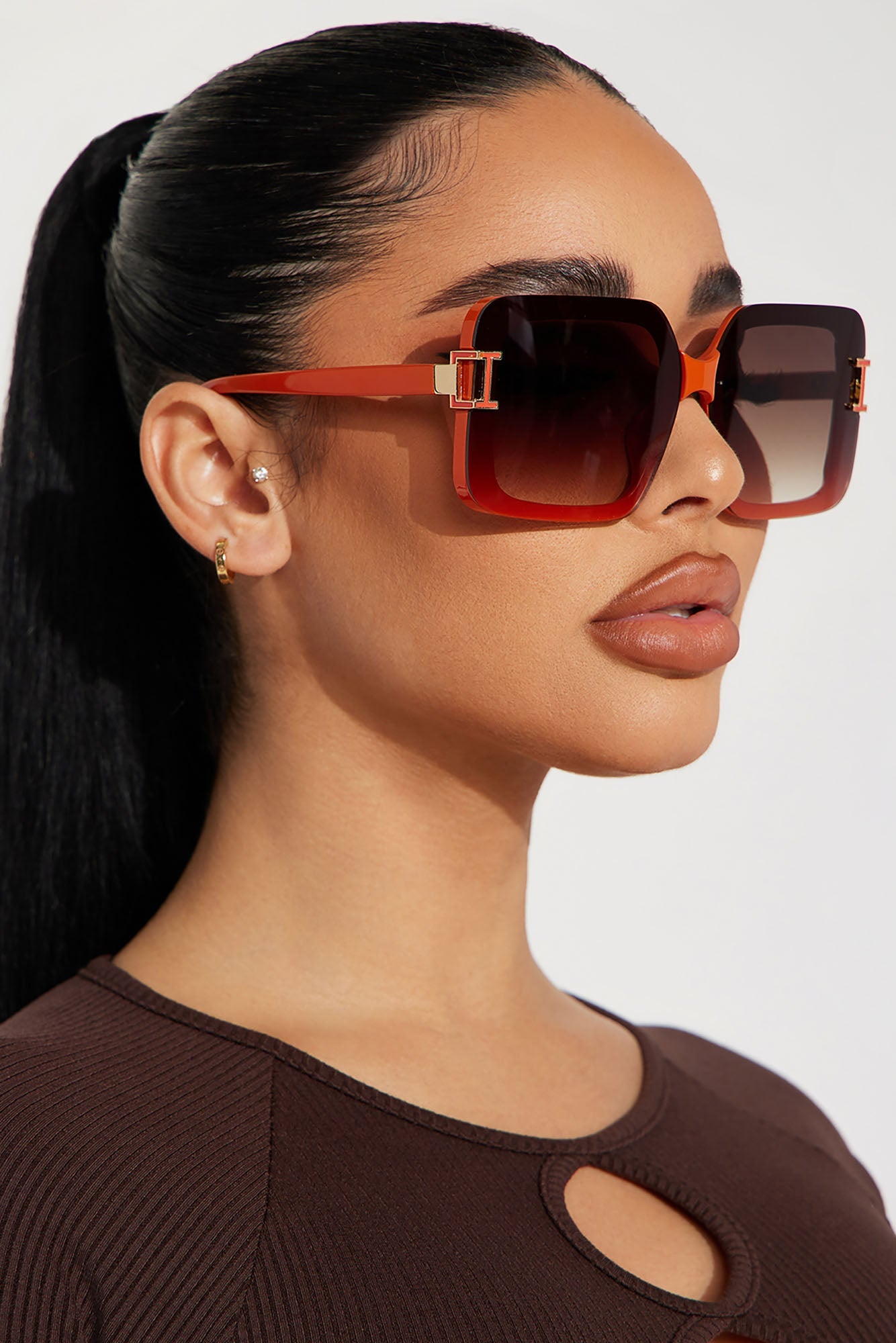 Woman wearing red sunglasses with a plain background