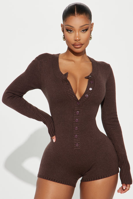 Woman wearing a brown ribbed knit romper with buttons on a white background