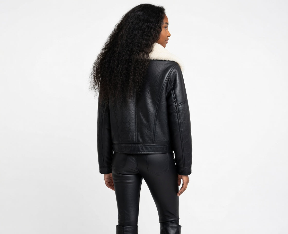 Person wearing a black leather jacket and pants on a white background