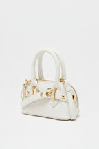 white handbag with silver hardware on a light gray background