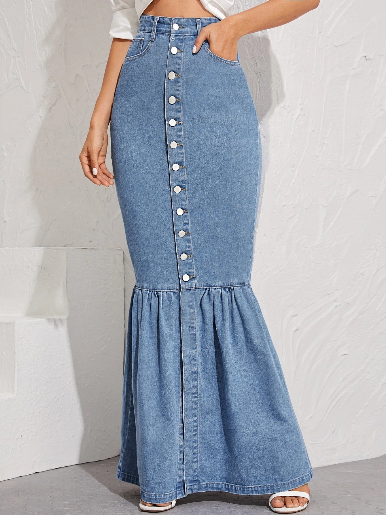 Denim skirt with button details worn by a person on a white background