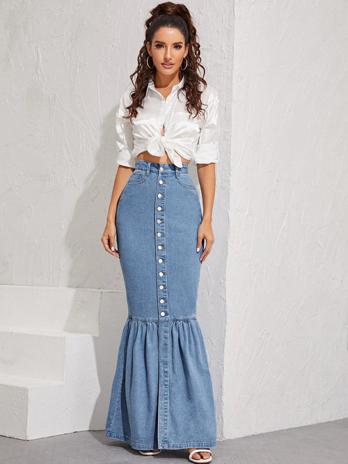 Woman wearing a white blouse and blue denim skirt against a light gray background