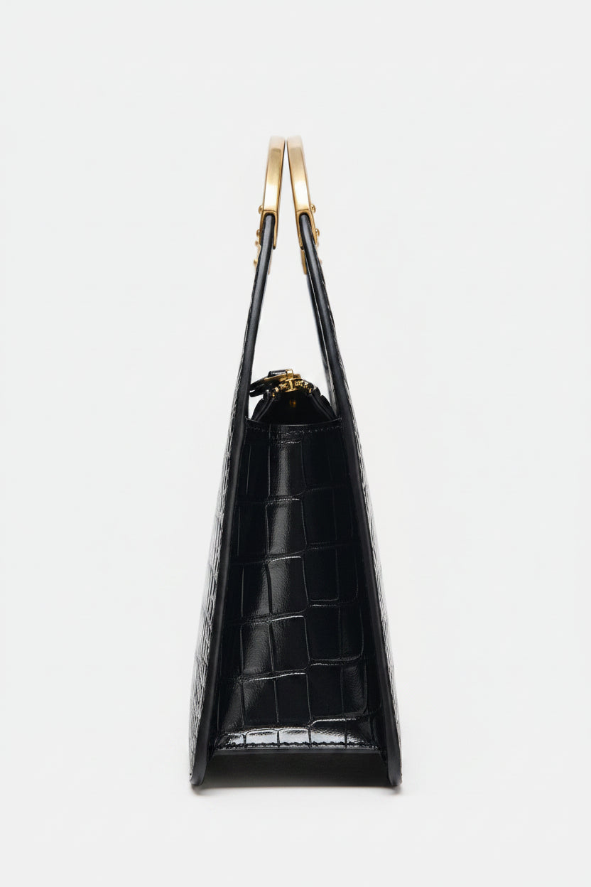 Black handbag with gold handles on a white background