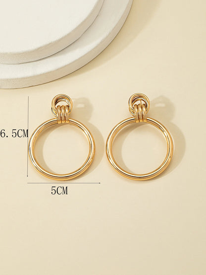 Gold hoop earrings on a beige background with measurements indicated.