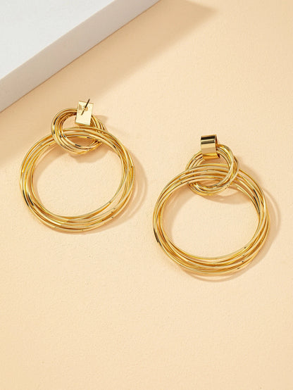 FAVEN Gold hoop earrings on a beige background