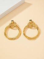 FAVEN Gold hoop earrings on a beige background