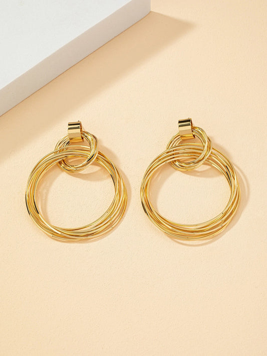 FAVEN Gold hoop earrings on a beige background