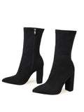 Black sock boots with block heels on a white background