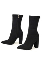 Black sock boots with block heels on a white background