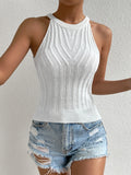 Person wearing a white ribbed tank top and denim shorts against a light gray background