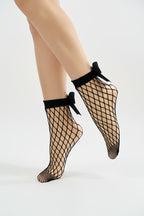 Black fishnet socks with bow details on a white background