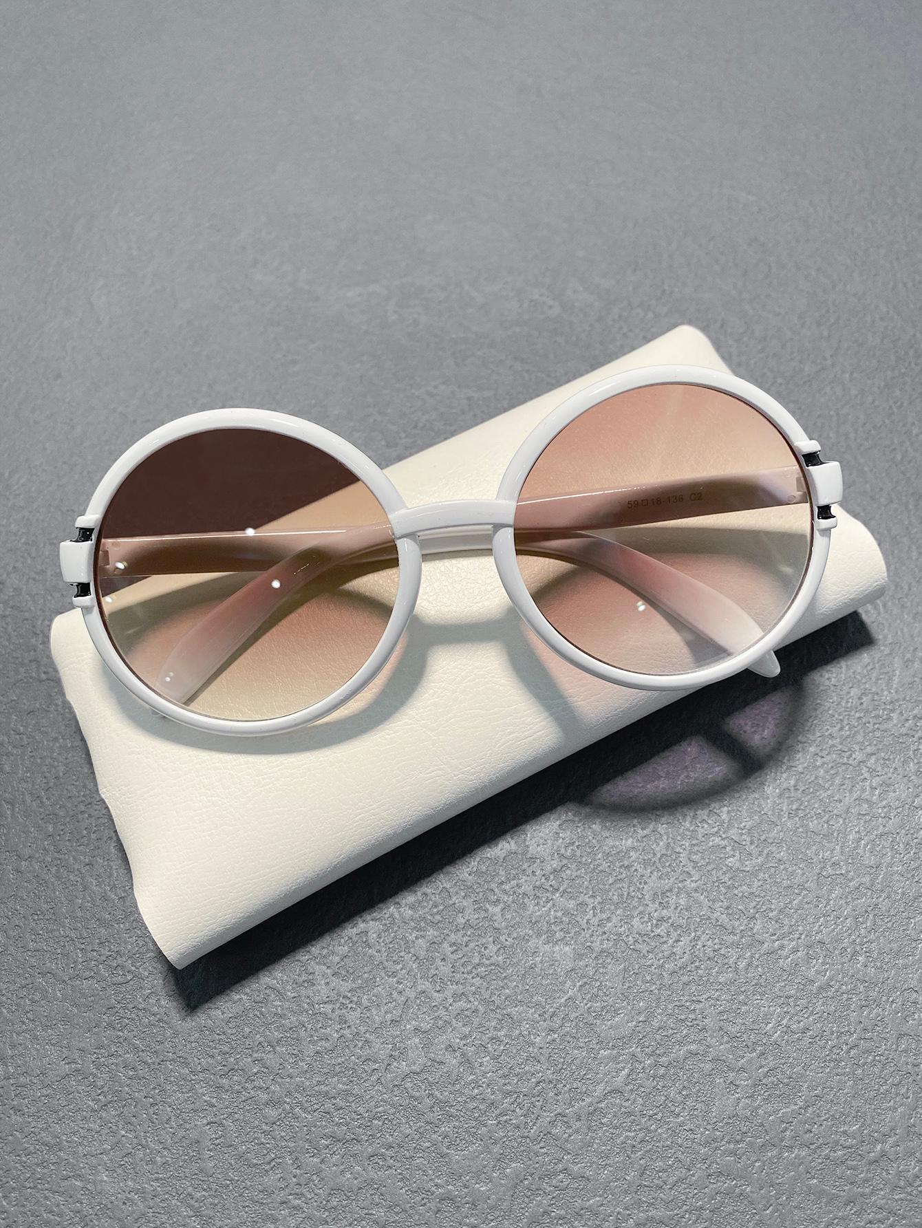 White sunglasses with brown lenses on a gray surface