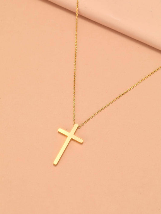 Gold cross necklace on a pink background