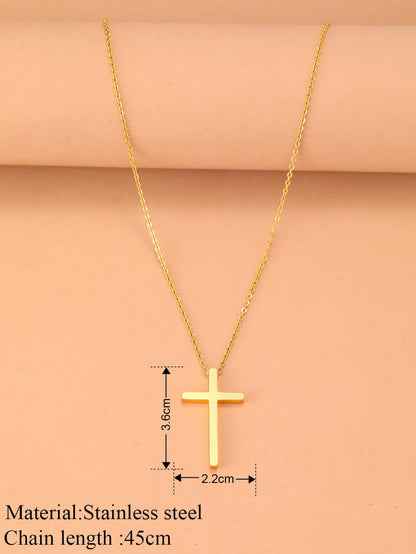 Gold cross necklace with measurements on a pink background