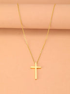 Gold cross necklace on a beige background