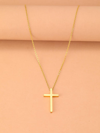 Gold cross necklace on a beige background