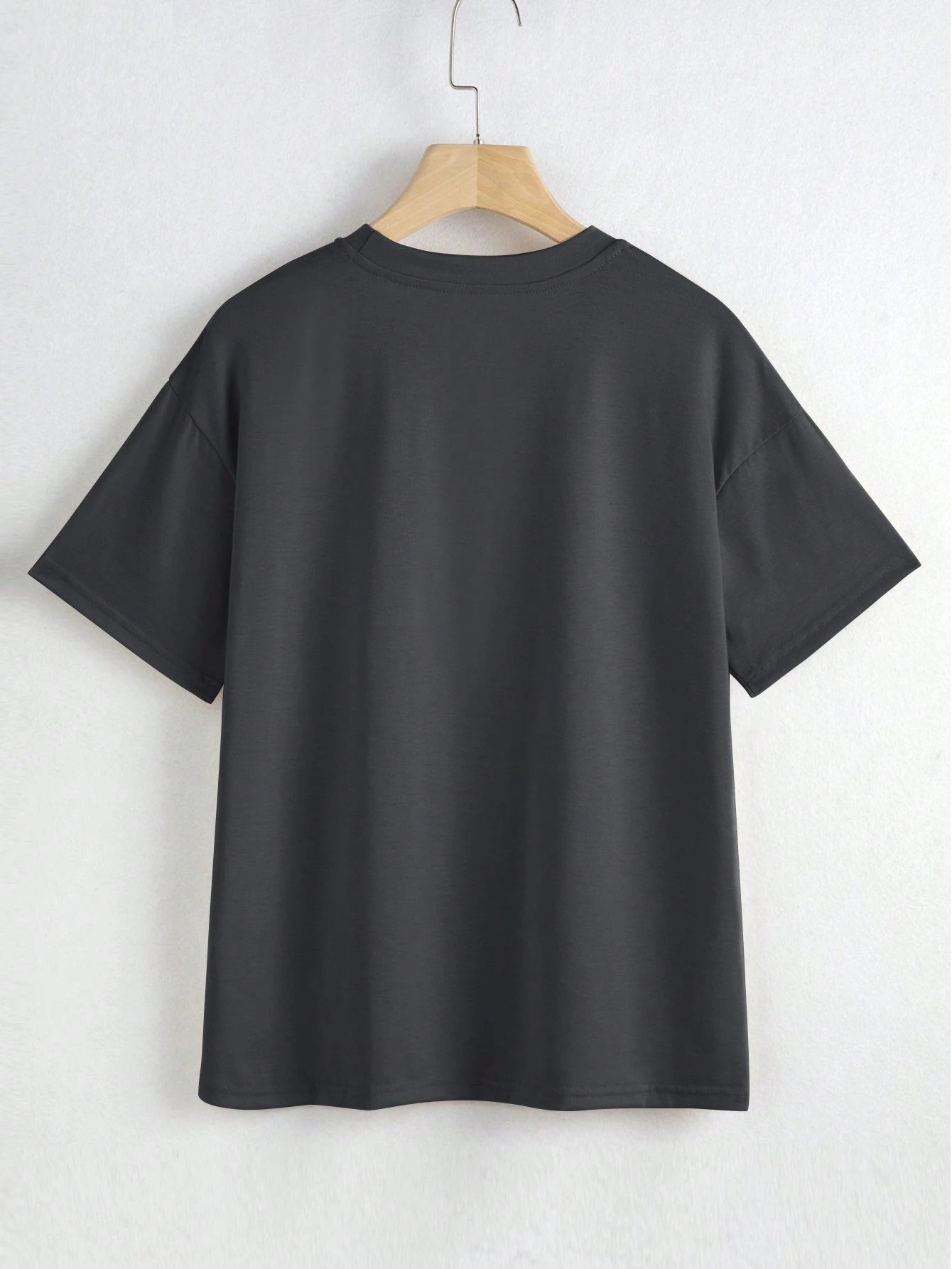 Black t-shirt on a hanger against a white background