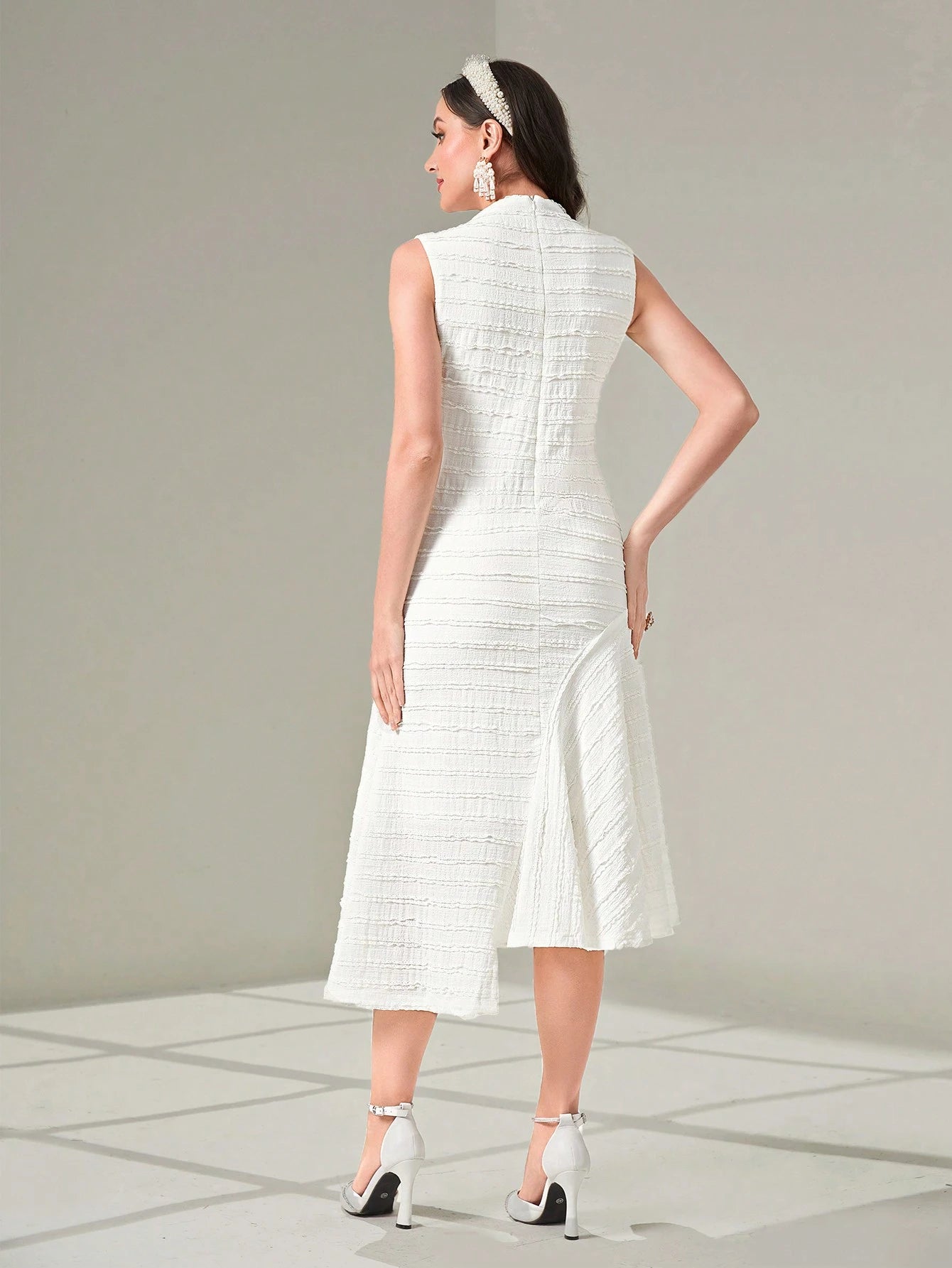 Woman wearing a white dress with a plain background