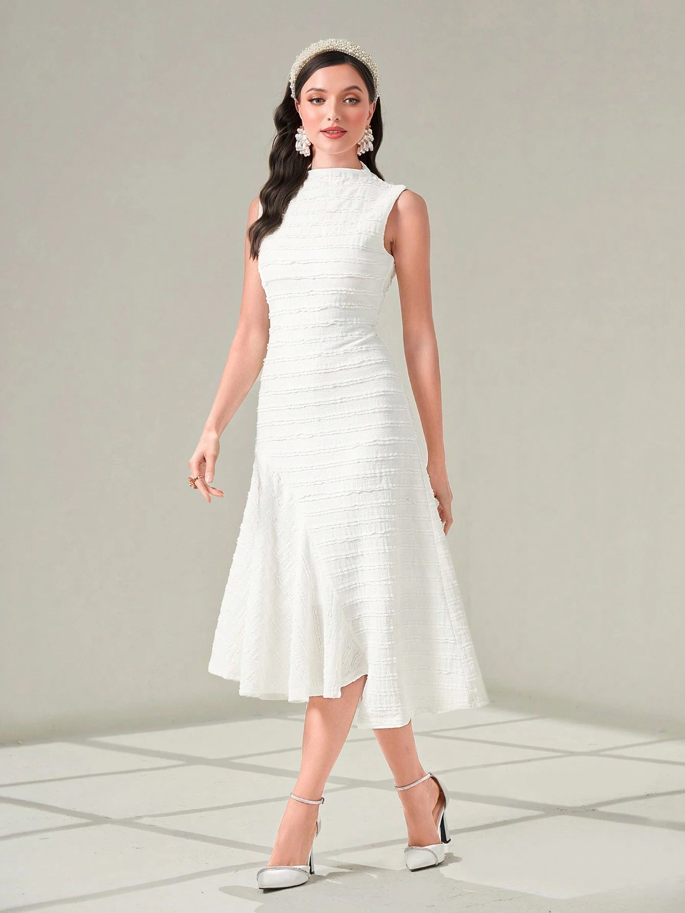 Woman wearing a white dress with a plain background