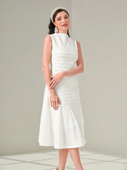 Woman wearing a white dress with a textured pattern on a light gray background
