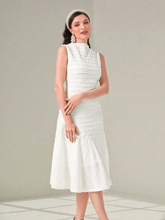 Woman wearing a white dress with a textured pattern on a light gray background
