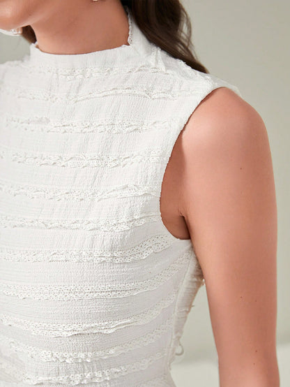 Close-up of a person wearing a textured white sleeveless top against a neutral background