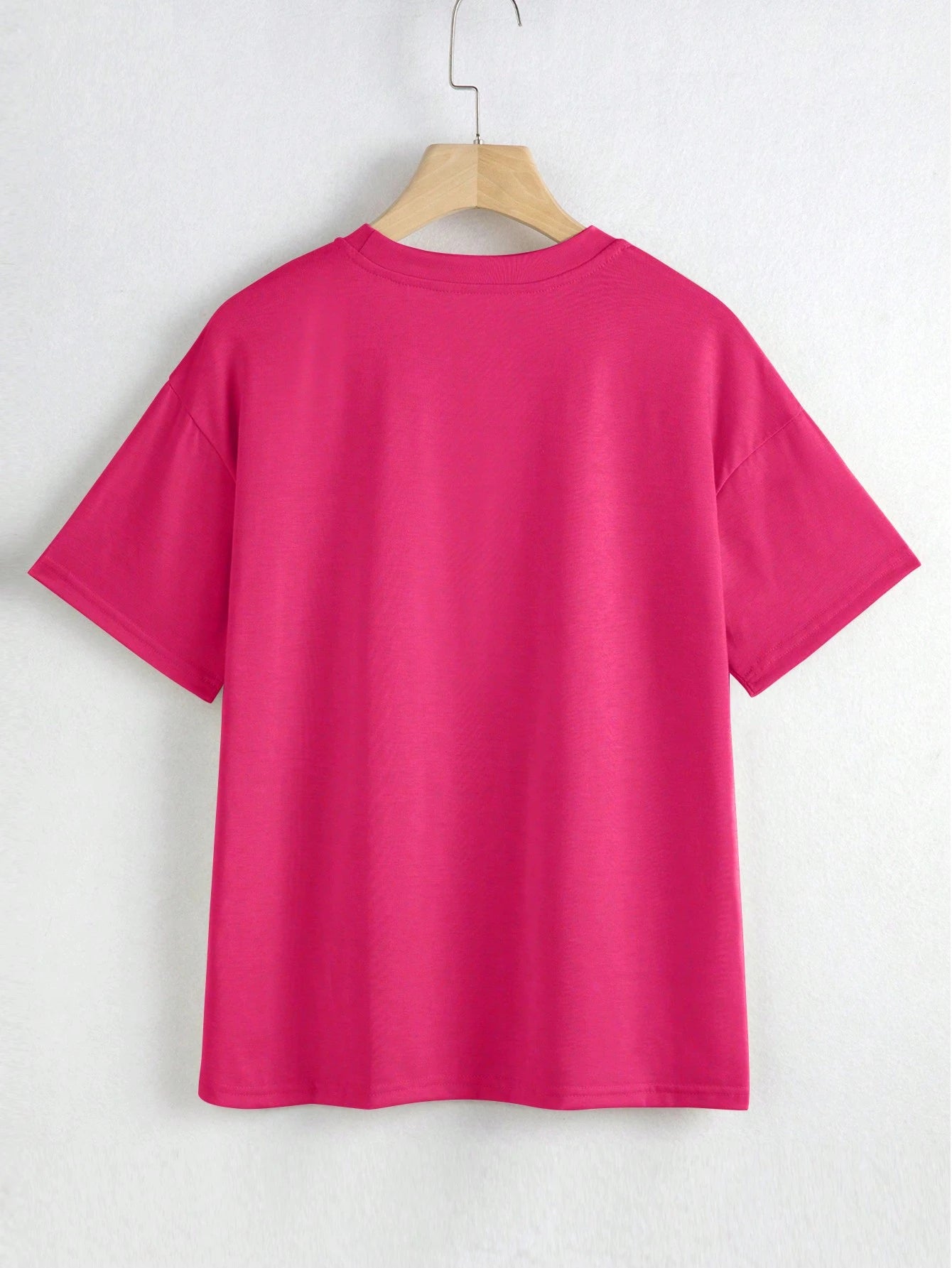 Pink t-shirt on a hanger against a white background