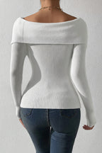 White off-shoulder sweater worn by a person against a plain background