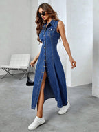 Woman wearing a long denim dress with a high slit, standing in an indoor setting.