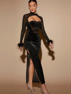 Woman wearing a black dress with sheer sleeves and a high slit on a beige background