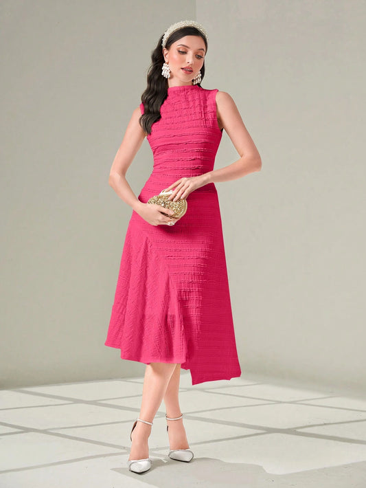 Woman wearing a pink dress holding a clutch against a neutral background