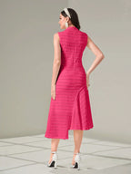Woman wearing a pink dress with a textured pattern on a gray background