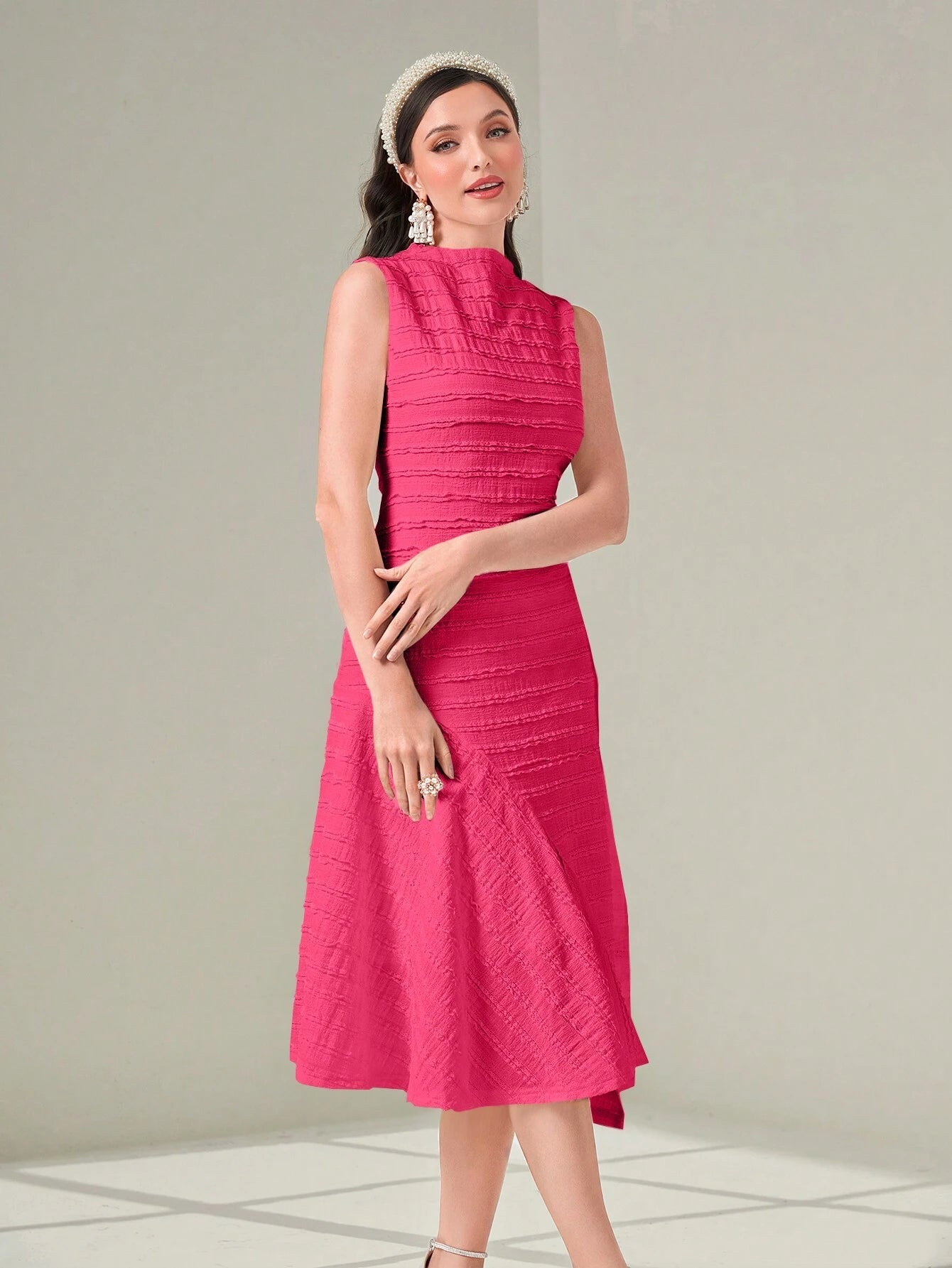 Woman wearing a pink dress against a light gray background