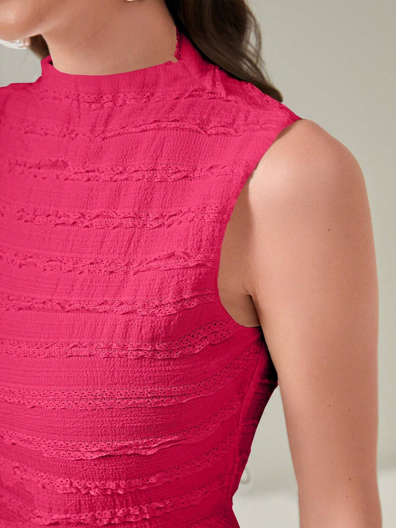 Close-up of a person wearing a bright pink sleeveless top against a neutral background