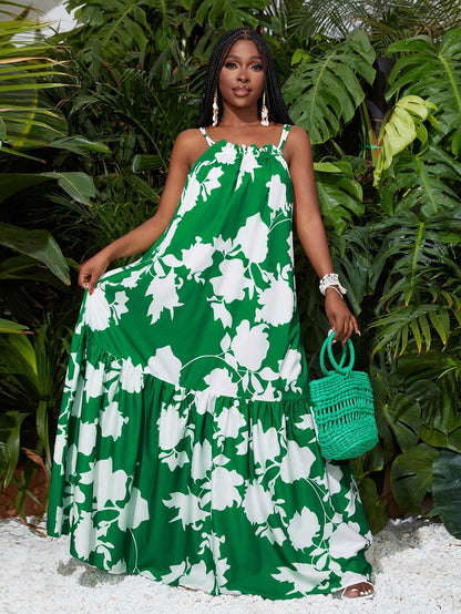 Woman wearing a green and white floral dress holding a green bag in front of green foliage.