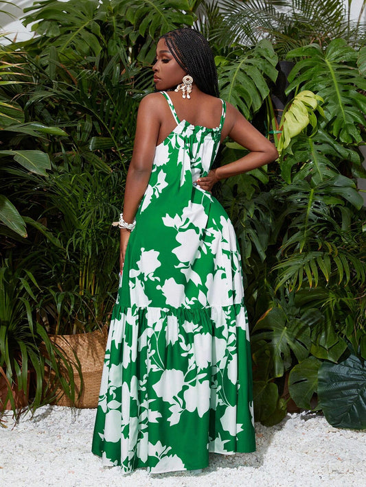 Woman wearing a green and white floral dress standing in front of green plants.