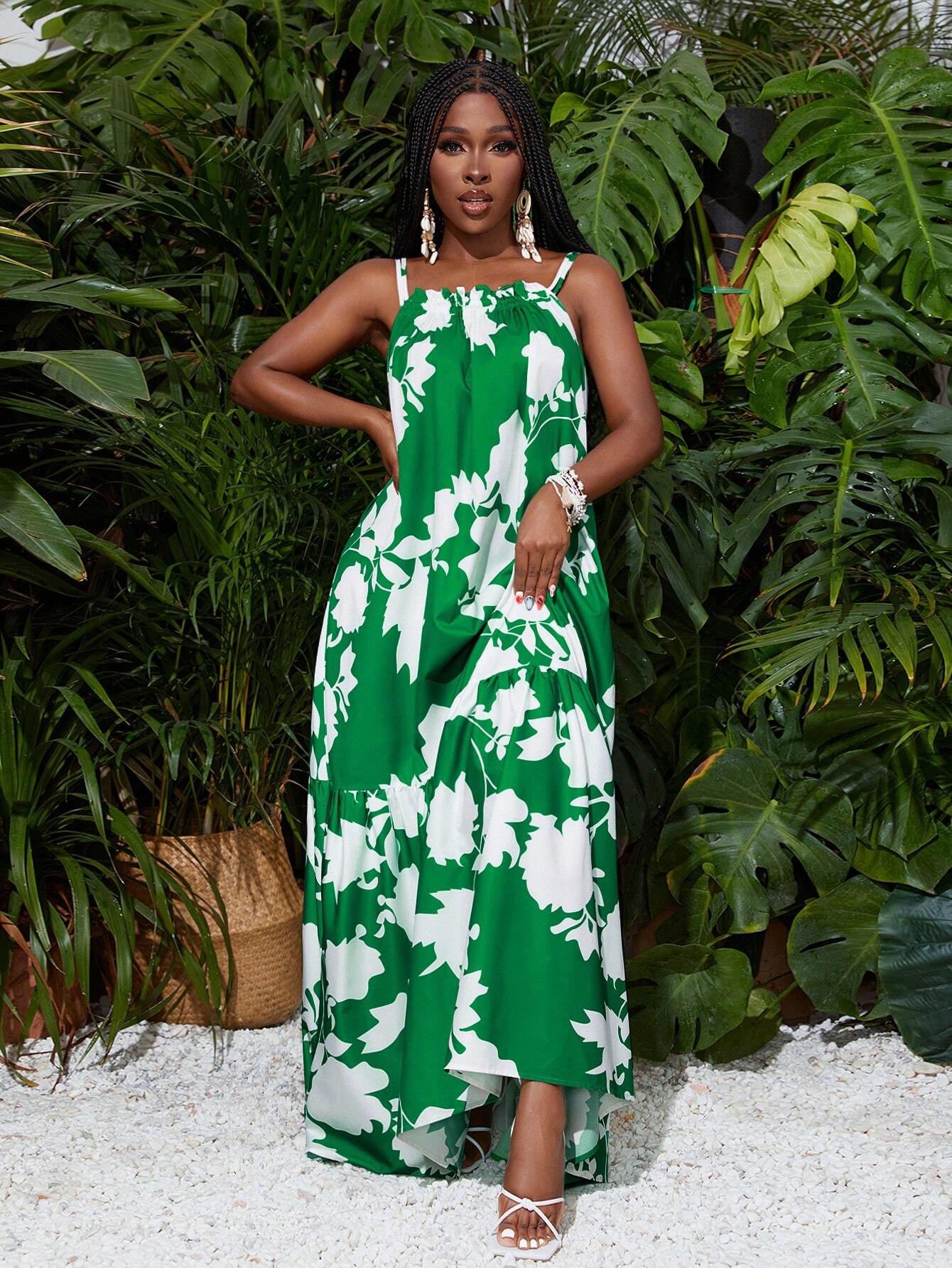 Woman in a green and white floral dress standing in front of tropical plants.