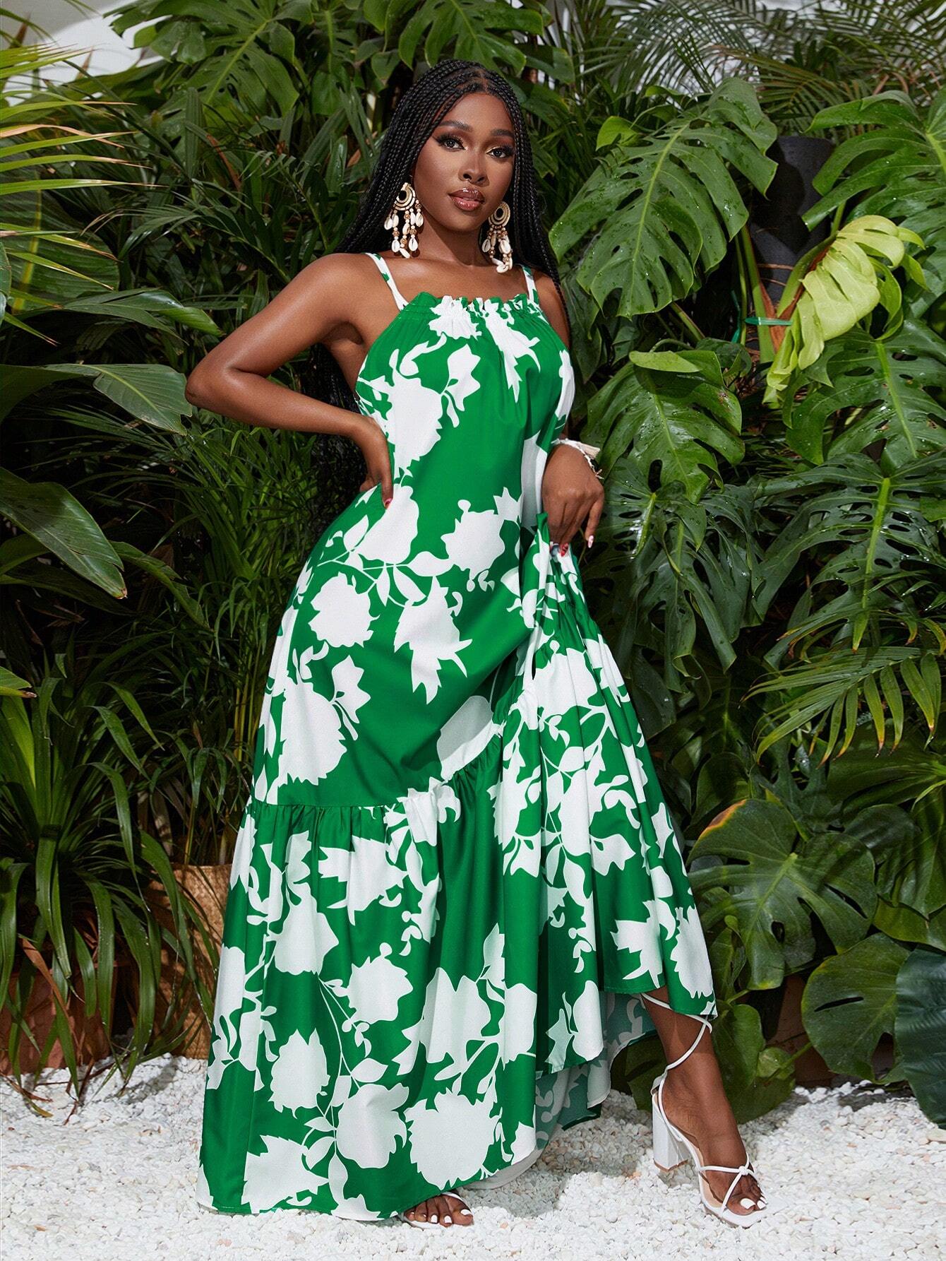 Woman in a green and white floral dress standing in front of green foliage