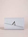 Silver glitter clutch bag with a black clasp on a beige background