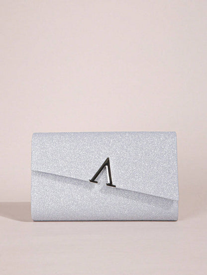 Silver glitter clutch bag with a black clasp on a beige background