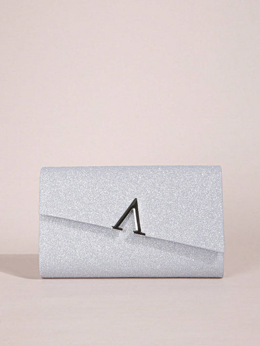 Silver glitter clutch bag with a black clasp on a beige background