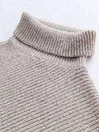 Close-up of a textured beige sweater with a high collar on a light gray background