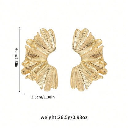 FAVEN Gold earrings worn by a person with a neutral background