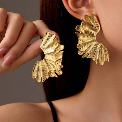 FAVEN Gold earrings worn by a person with a neutral background