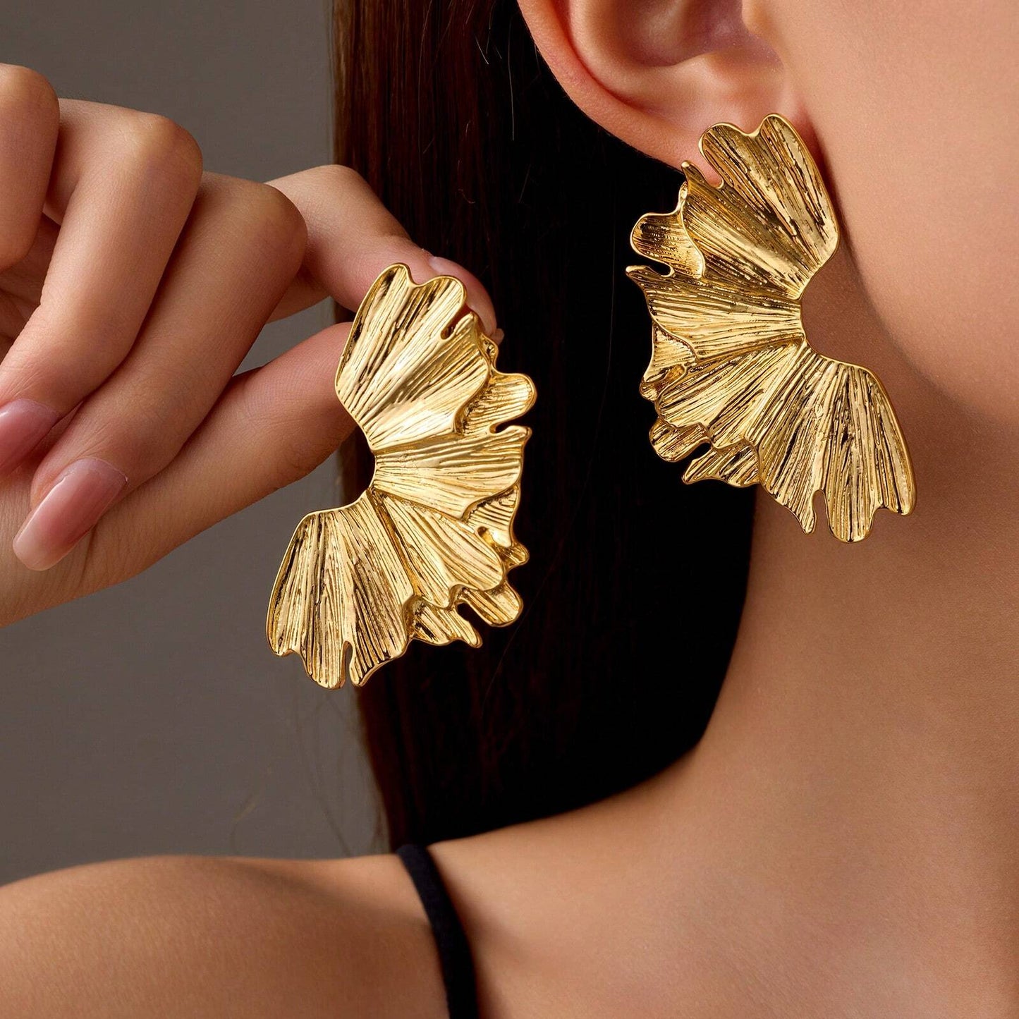 FAVEN Gold earrings worn by a person with a neutral background