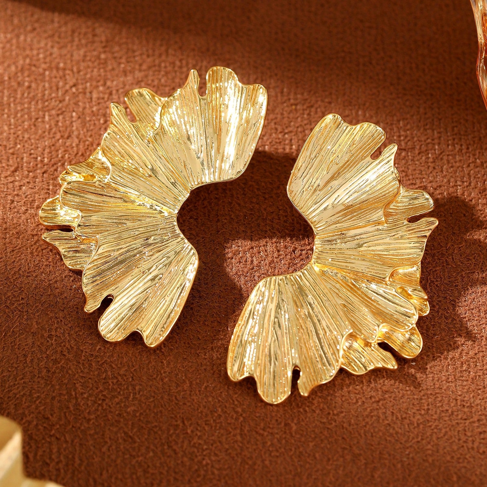 FAVEN Gold earrings worn by a person with a neutral background