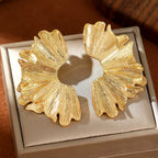 FAVEN Gold earrings worn by a person with a neutral background